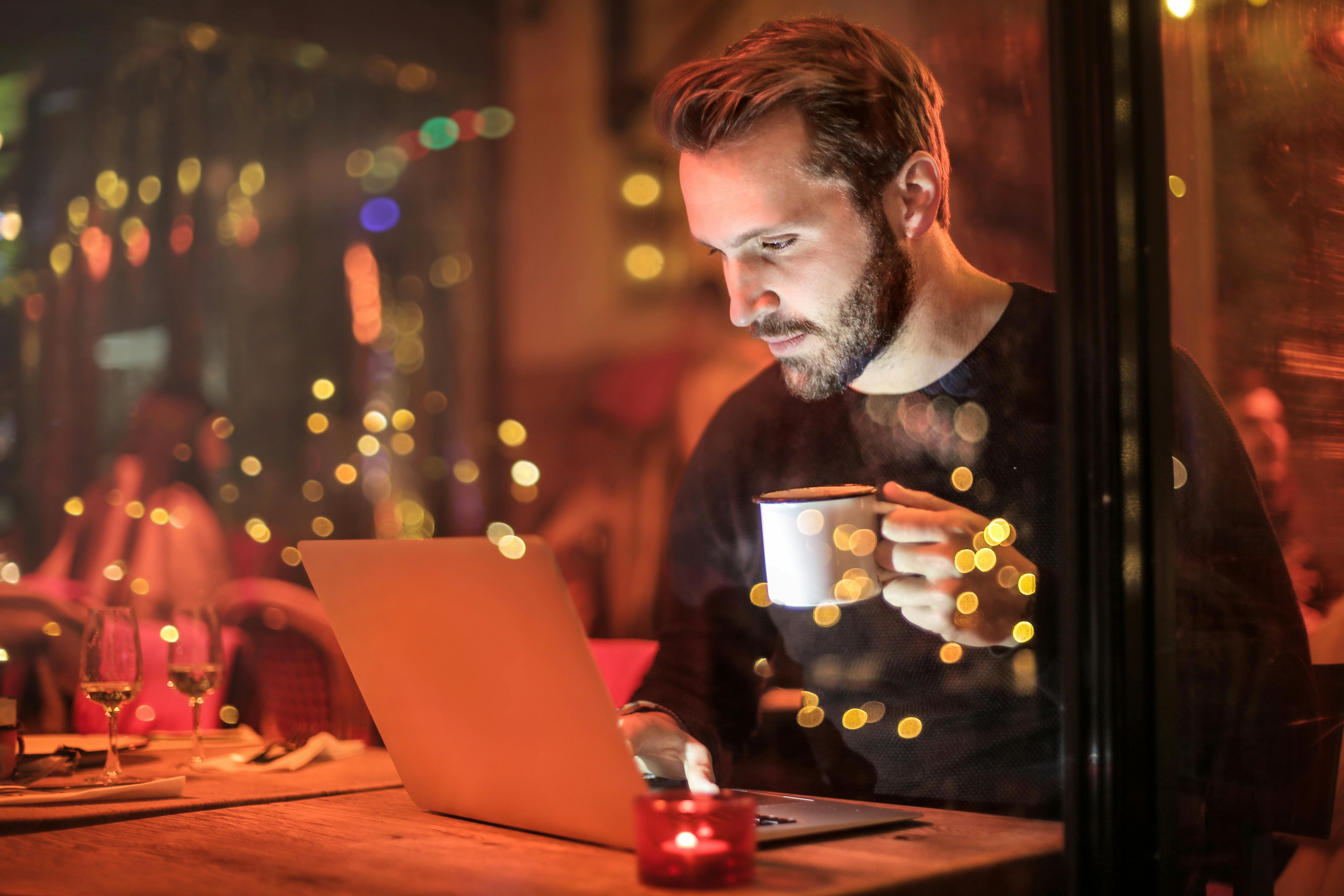 A man sat at a laptop working.