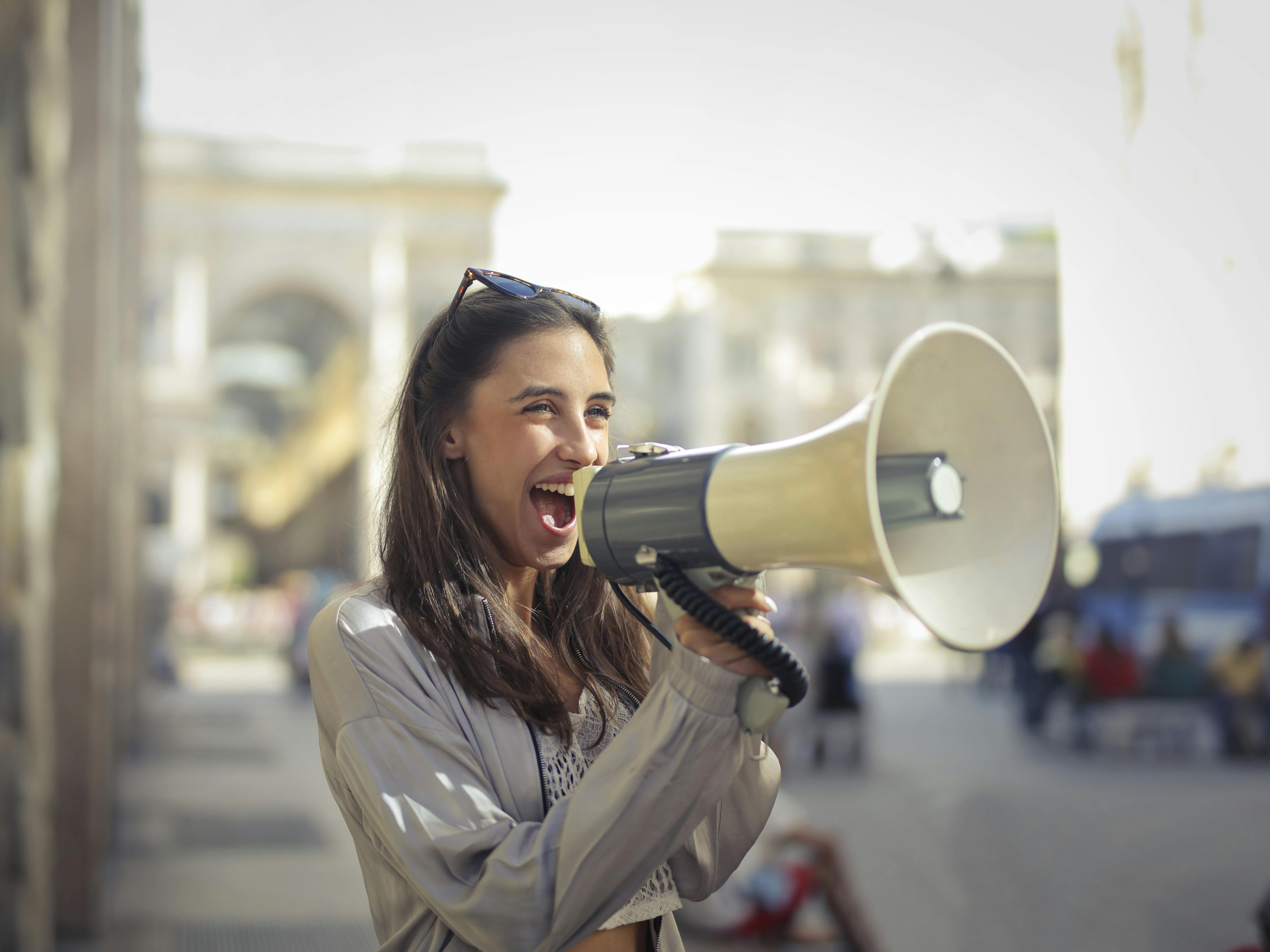 A lady on the street with a megaphone<br>